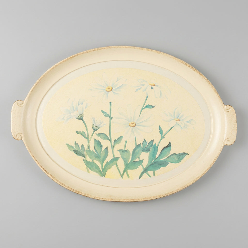 An oval ceramic serving tray with side handles, featuring a painted illustration of white daisies with green stems and leaves on a pale cream background.