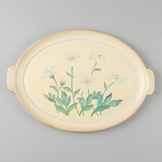 An oval ceramic serving tray with side handles, featuring a painted illustration of white daisies with green stems and leaves on a pale cream background.